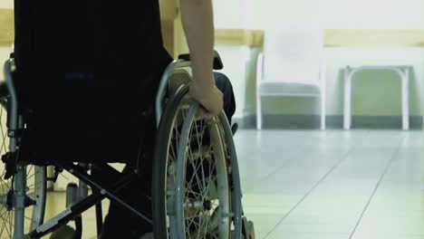 un joven conduce a través de un corredor del hospital en una silla de ruedas 1