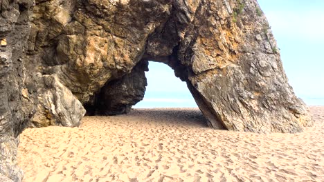 Praia-da-Adraga-sandy-beach-with-blue-ocean-in-background,-Sintra-Cascais,-Portugal