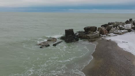 vista aérea de los edificios de fortificación costeros abandonados en los fuertes del norte de karosta en la playa del mar báltico, día de invierno nublado, amplio tiro de drones avanzando