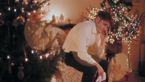 pensive man sitting at decorated home during christmas