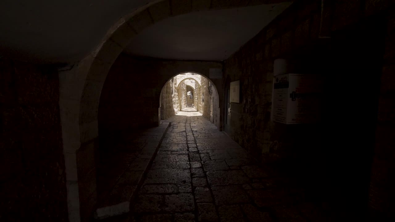 caminando a través del arco del túnel oscuro en el muro occidental en la ciudad vieja de jerusalén en israel