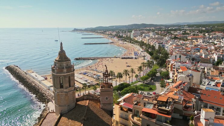 Drone captures stunning aerial footage of an ancient church overseeing a charming coastal town by azure sea on a sunny day