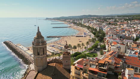 drone captures stunning aerial footage of an ancient church overseeing a charming coastal town by azure sea on a sunny day