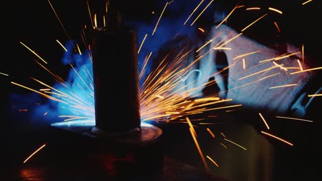 a welder in a protective helmet and clothes welds as sparks fly 2