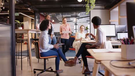 diverse female business creatives discussing project at work, in slow motion