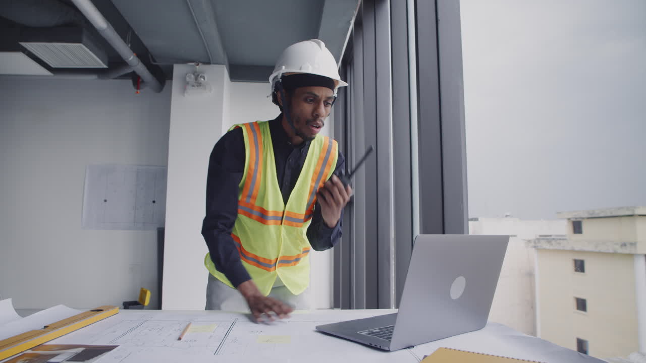 Foreman Using Walkie-talkie while Planning Work of Team on Construction Site
