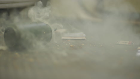 smoke grenade is thrown over a really dirty blue carpet