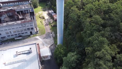 Torre-De-Agua-De-Hormigón-Brutalista-En-El-Centro-De-Investigación-Vértigo-Disparado-A-Un-Charco-Con-Fugas-En-Un-Bosque-Fangoso-Mosh-Pit-Agua-Verde