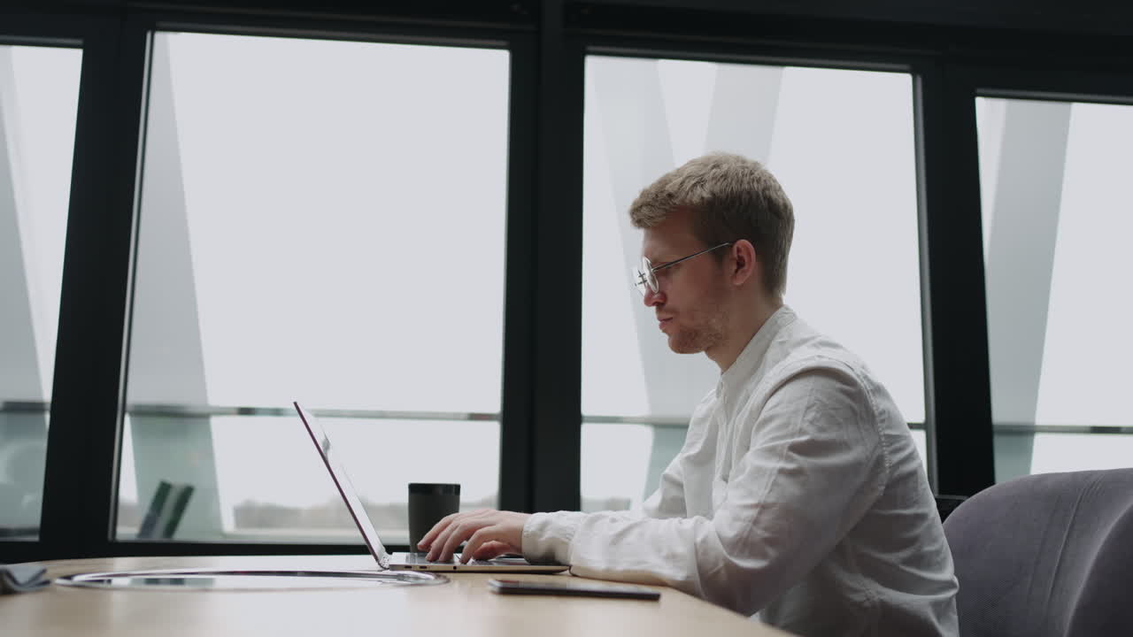 프리랜서 프로그래머 또는 번역자는 카페 또는 공동 작업 공간에서 노트북으로 키보드에 텍스트를 입력하고 있습니다.