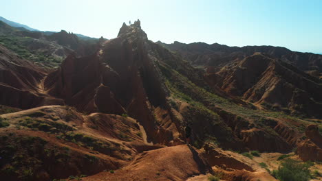 Hombre-Caminando-En-La-Cresta-Del-Cañón-En-El-Cañón-De-Cuento-De-Hadas-Cerca-Del-Lago-Issyk-kul-En-Karakol,-Kirguistán,-Tiro-Giratorio-Aéreo