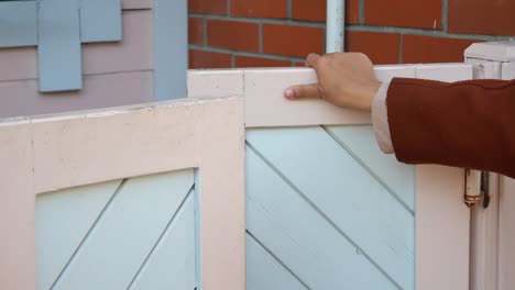 mujer abriendo una puerta de madera