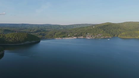 Slow drone flight over the beautiful Solina Lake towards the dam on a sunny day