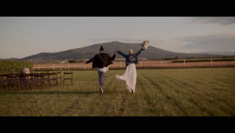 couple running away from wedding ceremony