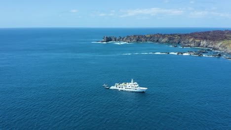 white diveboat in punta tosca rocky coastline of socorro island in revillagigedo archipelago