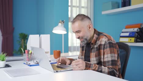 Freelance-businessman-laughing-and-having-fun-at-what-he-sees-on-the-laptop.