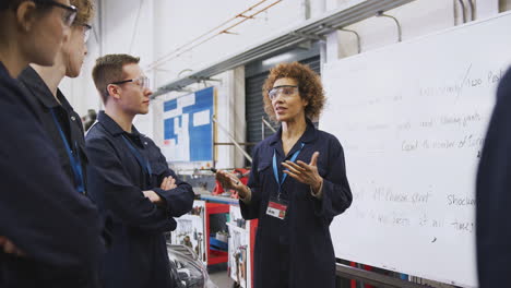 Nachhilfelehrerin-Am-Whiteboard-Mit-Studenten,-Die-An-Der-Hochschule-Eine-Kfz-Mechaniker-Ausbildung-Unterrichten