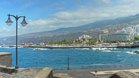 View-at-magnificent-city-Puerto-de-la-Cruz,-surrounded-by-azure-ocean-and-mountains