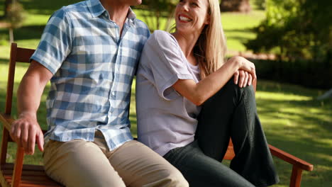 una pareja relajándose en el parque en un banco.