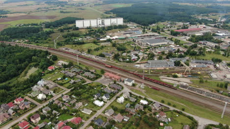 Railway-tracks-with-carts-and-massive-agriculture-industrial-building-in-Jonava,-aerial-drone-view