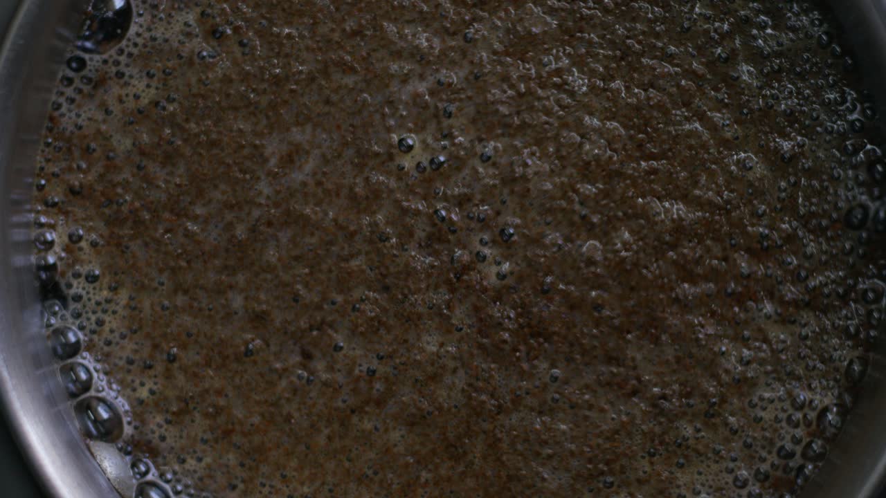A detailed closeup top view of bubbling tea with foam on fire, tea prepare process