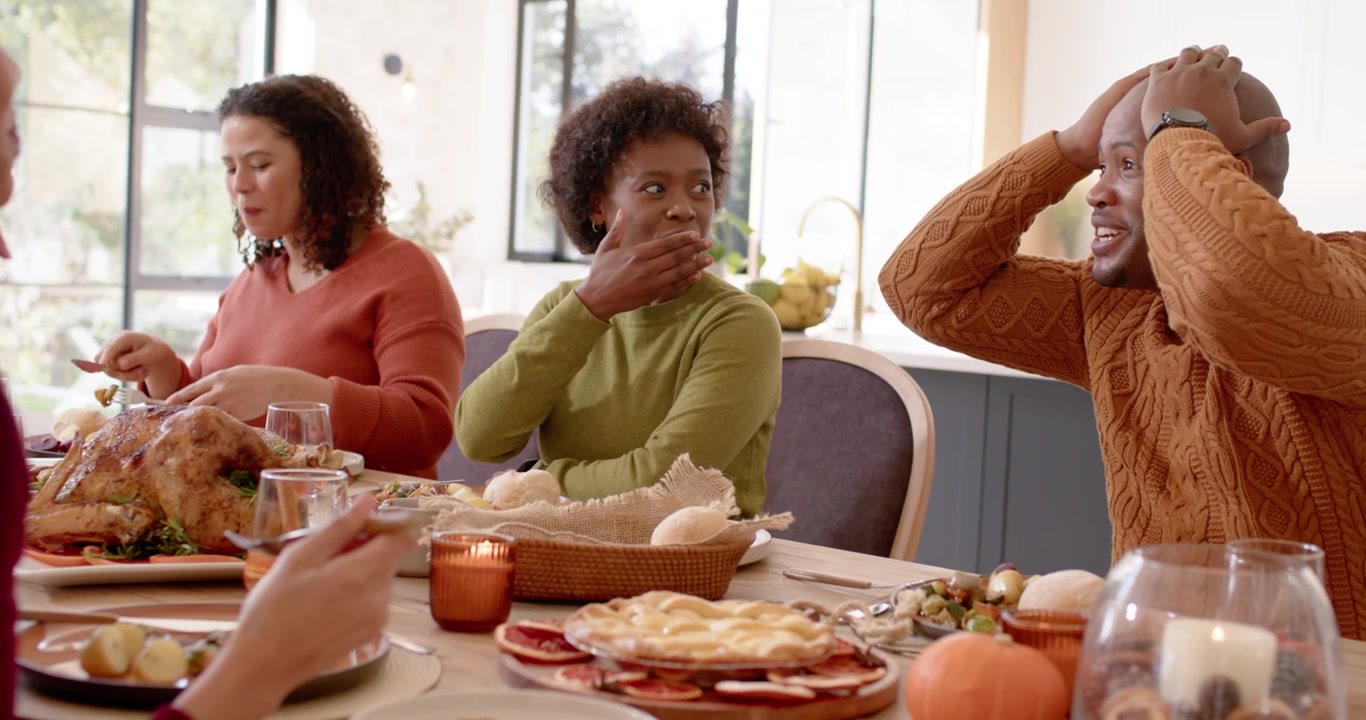 Familia diversa teniendo una conversación impactante durante la cena de Acción de Gracias.