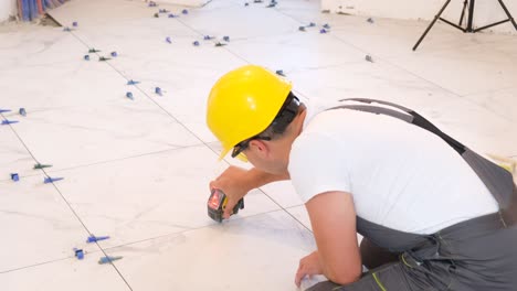 construction repair of laying ceramic tiles on a concrete floor the worker makes repairs in the