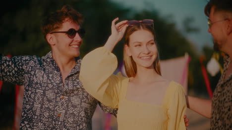 happy beautiful woman with male friends wearing sunglasses