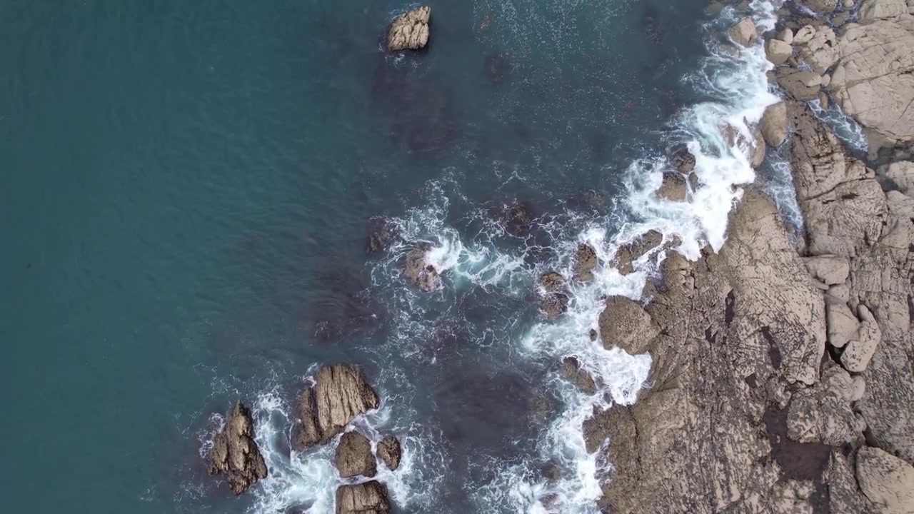 Una ripresa aerea con tracking laterale leggermente circolare della costa rocciosa della Bretagna, Francia, che cattura il terreno accidentato e le onde dell'oceano. Ideale per riprese costiere dinamiche e scene naturalistiche