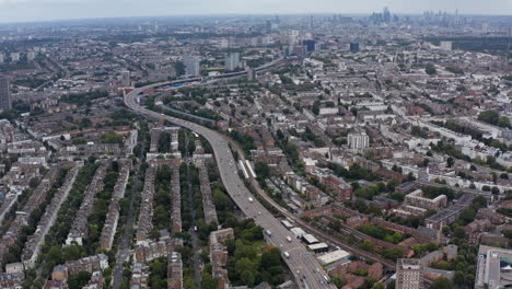 Amplia-Vista-Panorámica-Del-Distrito-Residencial,-La-Autopista-Concurrida-Y-La-Vista-Inclinada-Hacia-Arriba-Del-Horizonte-Del-Centro.-Londres,-Reino-Unido