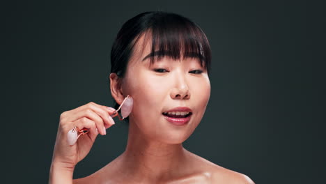 woman using a jade roller for facial massage