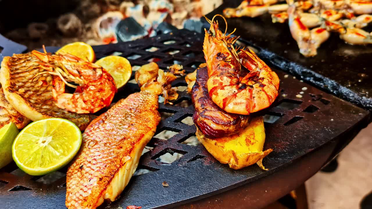 Pullback reveals cooked prawns, frog legs, citrus slices on vibrant platter of food