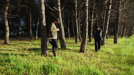 son uses phone and father observes winter forest during holiday