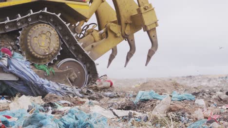 vehicles clearing rubbish piled on a landfill full of trash