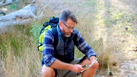 excursionista masculino con un mapa y equipo de orientación en el bosque 4k