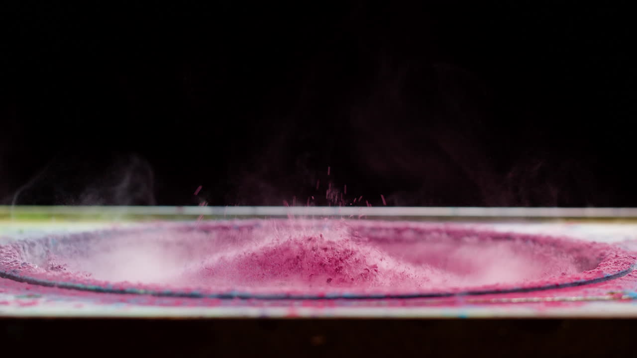 Polvere rosa che vibra e danza sul cono dell'altoparlante al rallentatore