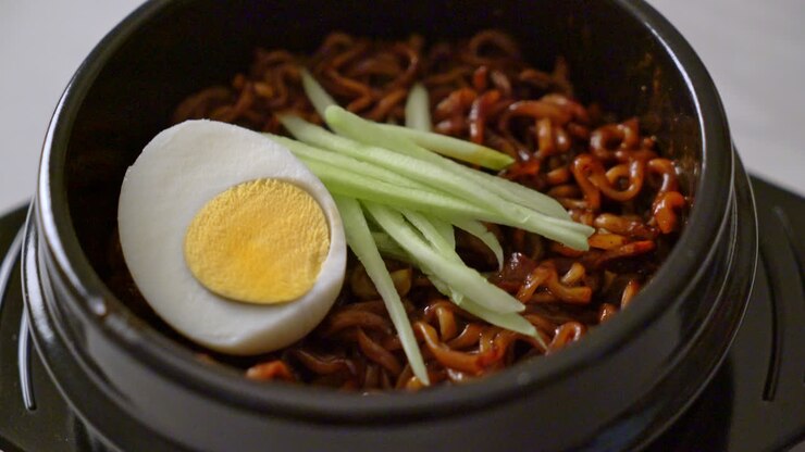 Noodles istantanei coreani con salsa di fagioli neri, guarniti con cetrioli e uovo sodo - Cucina coreana