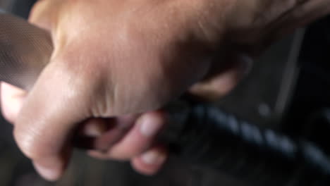 sliding close up shot of a hand gripping gym barbell getting ready to lift