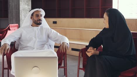 hombre y mujer guapos con ropa tradicional trabajando en una oficina de dubai