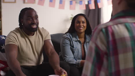 Friends-At-Home-Celebrating-With-Party-For-American-Independence-Day-4th-July-Talking-And-Eating-Snacks-2