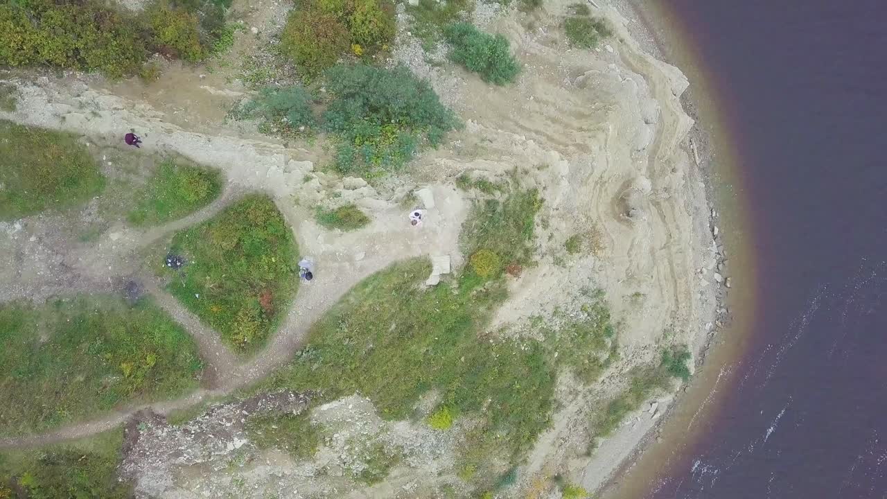 воздушный вид на скалу на берегу озера с людьми