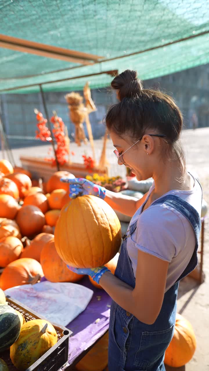 adolescente eligiendo calabazas en un mercado de agricultores