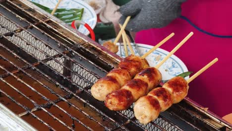 grilled thai sausage skewers at a street market