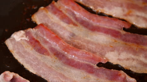 tocino cocinando en una sartén