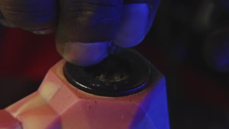 a black mans hand is breaking down marijuana bud to smoke it from a rubber pipe