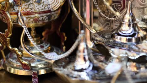 close-up view of ornate silver and gold teapots with intricate designs and decorative elements.