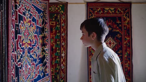 boy looking at traditional carpets