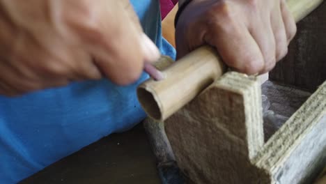 details of bamboo flute making by hand in a traditional workshop, musical instrument crafting