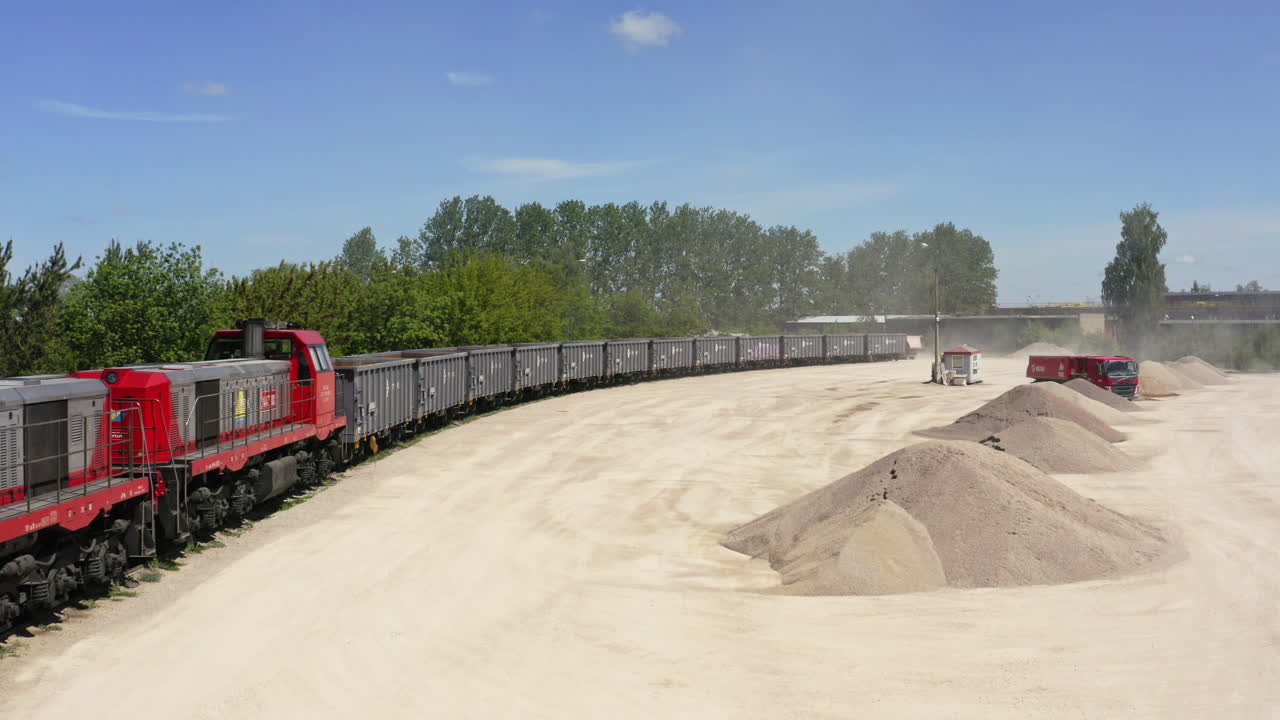 Dump Trucks Working At Dusty Processing Plant Of Quarry. - aerial shot