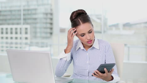 joven mujer de negocios haciendo cálculos y estresándose