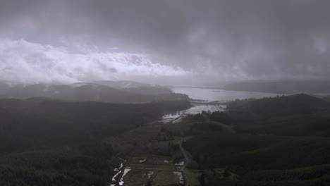 storm clouds gather over flooded coquille valley with dense forest during winter in oregon